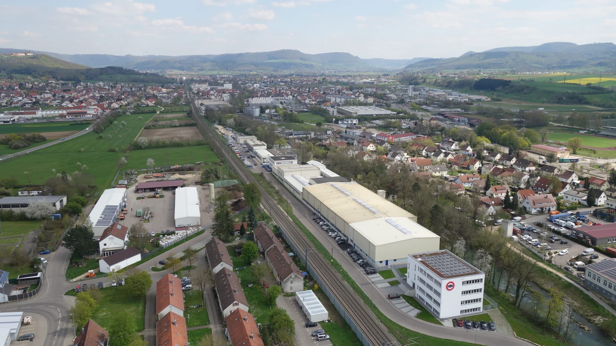 Bürogebäude und Halle im Zusammenhang, links die Gleise, rechts das Wohngebiet von Eislingen