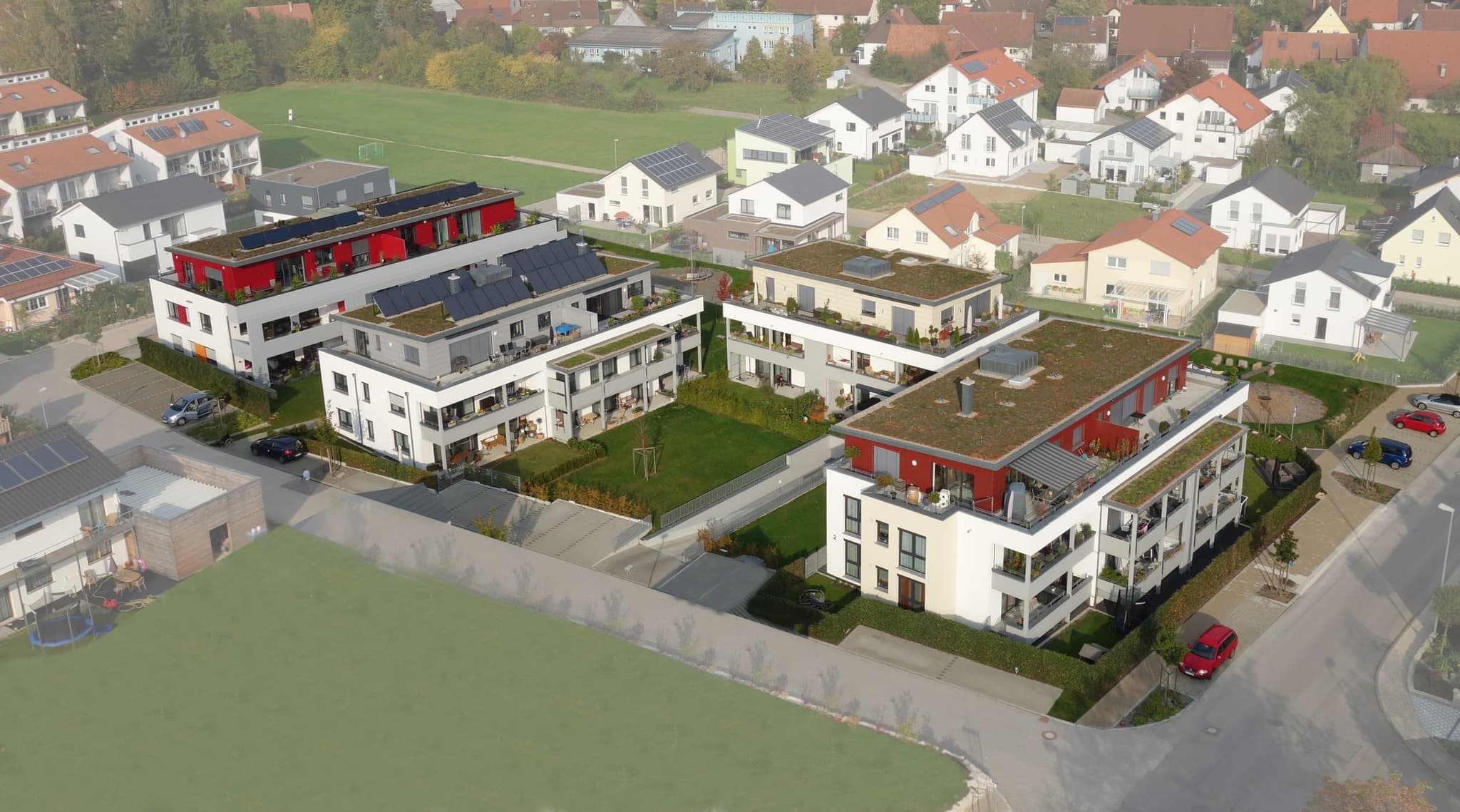 Die ganze Anlage aus größerer Höhe, mit Solarkollektoren auf den Dächern und dem Ort dahinter