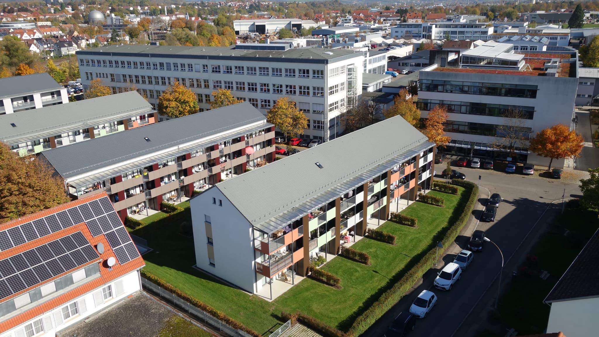 Zwei Wohnzeilen der Länge nach, mit dem großen Verwaltungsbau im Hintergrund