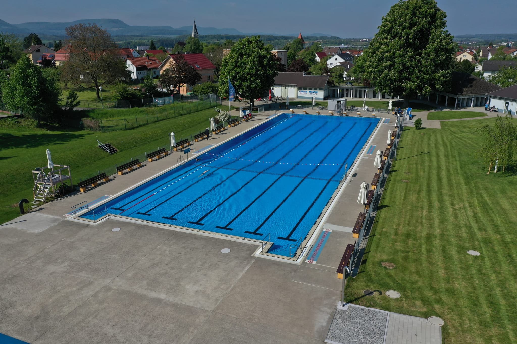 Das Schwimmerbecken aus niedriger Höhe, im Hintergrund Salach und die Albkette