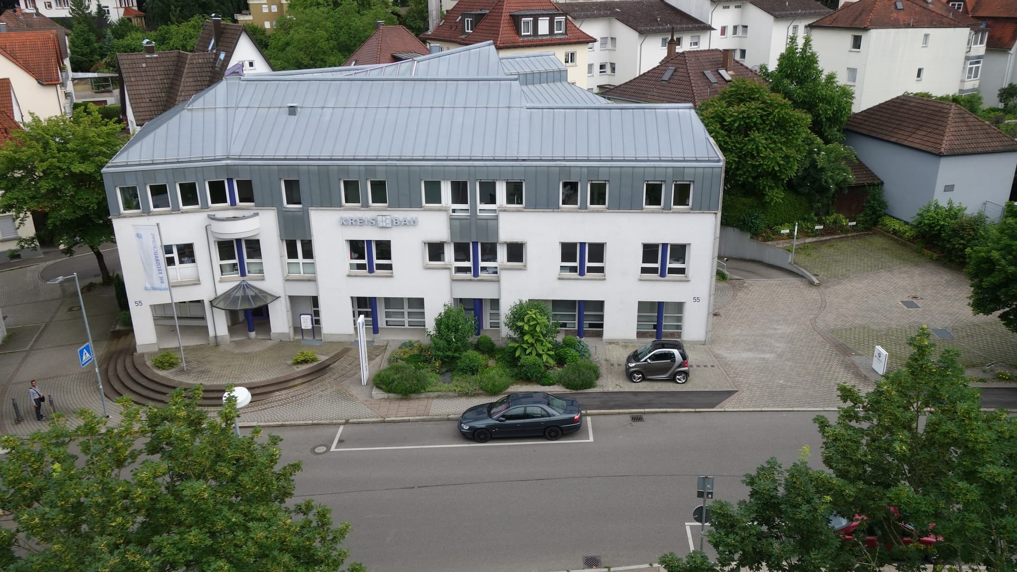 Der Verwaltungssitz mit Zinkdach und dem blauen Schriftzug KREISBAU über dem Eingang