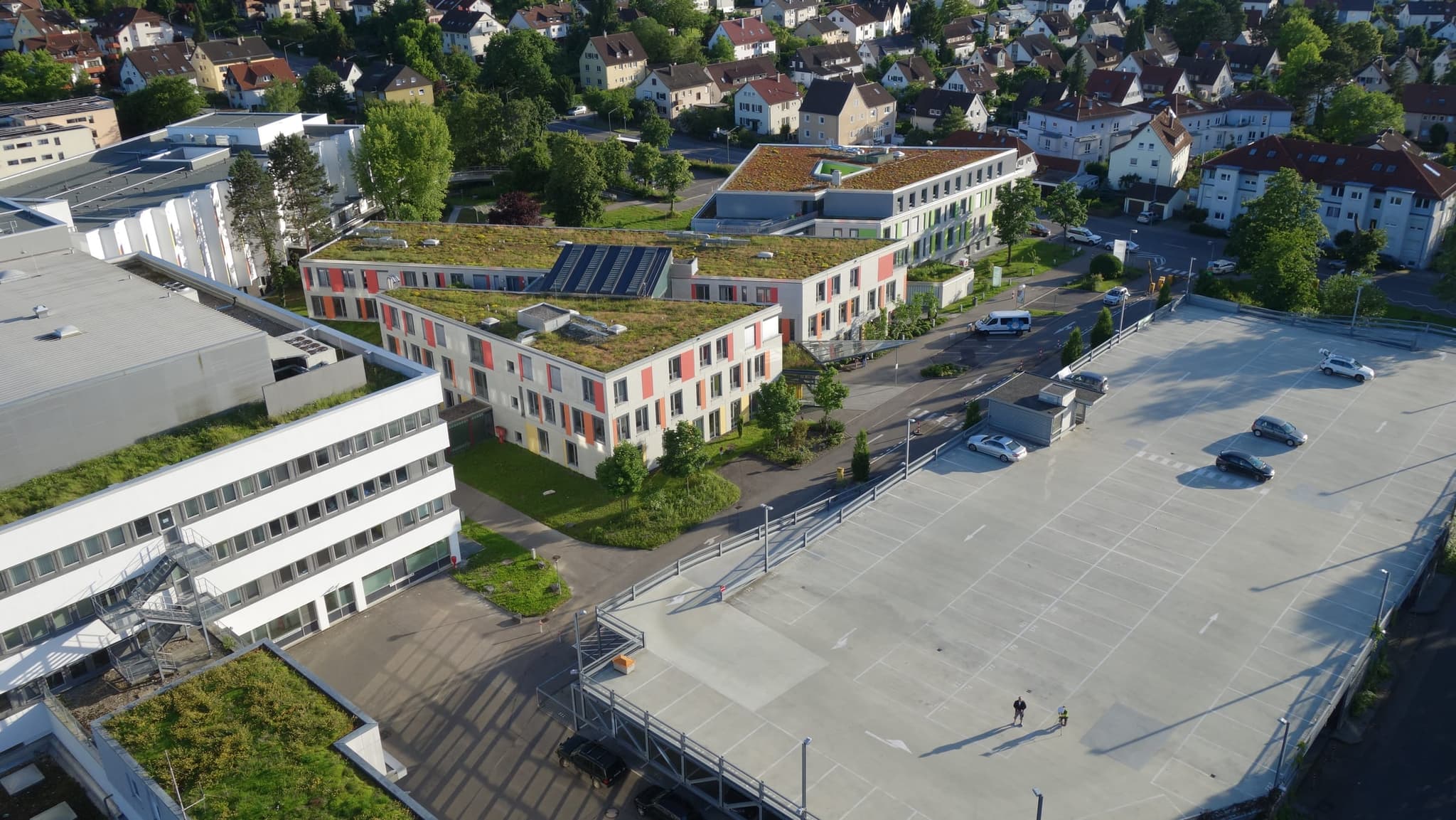 Der Neubauflügel mit roten und gelben Fassadenfeldern, davor das Parkdeck
