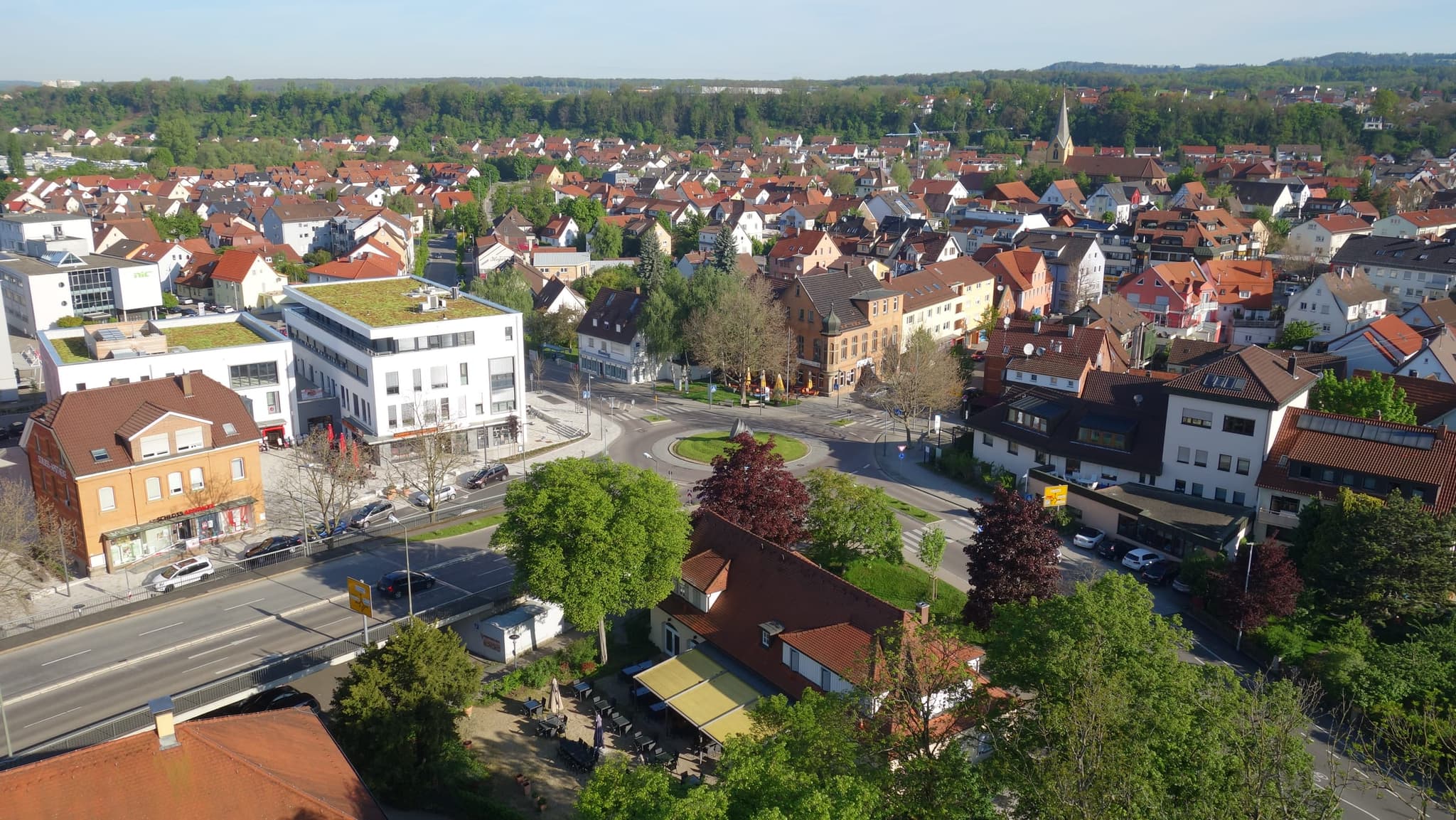 Der Kreisverkehr am Rathaus aus der Höhe, mit Biergarten und Ortsmitte dahinter