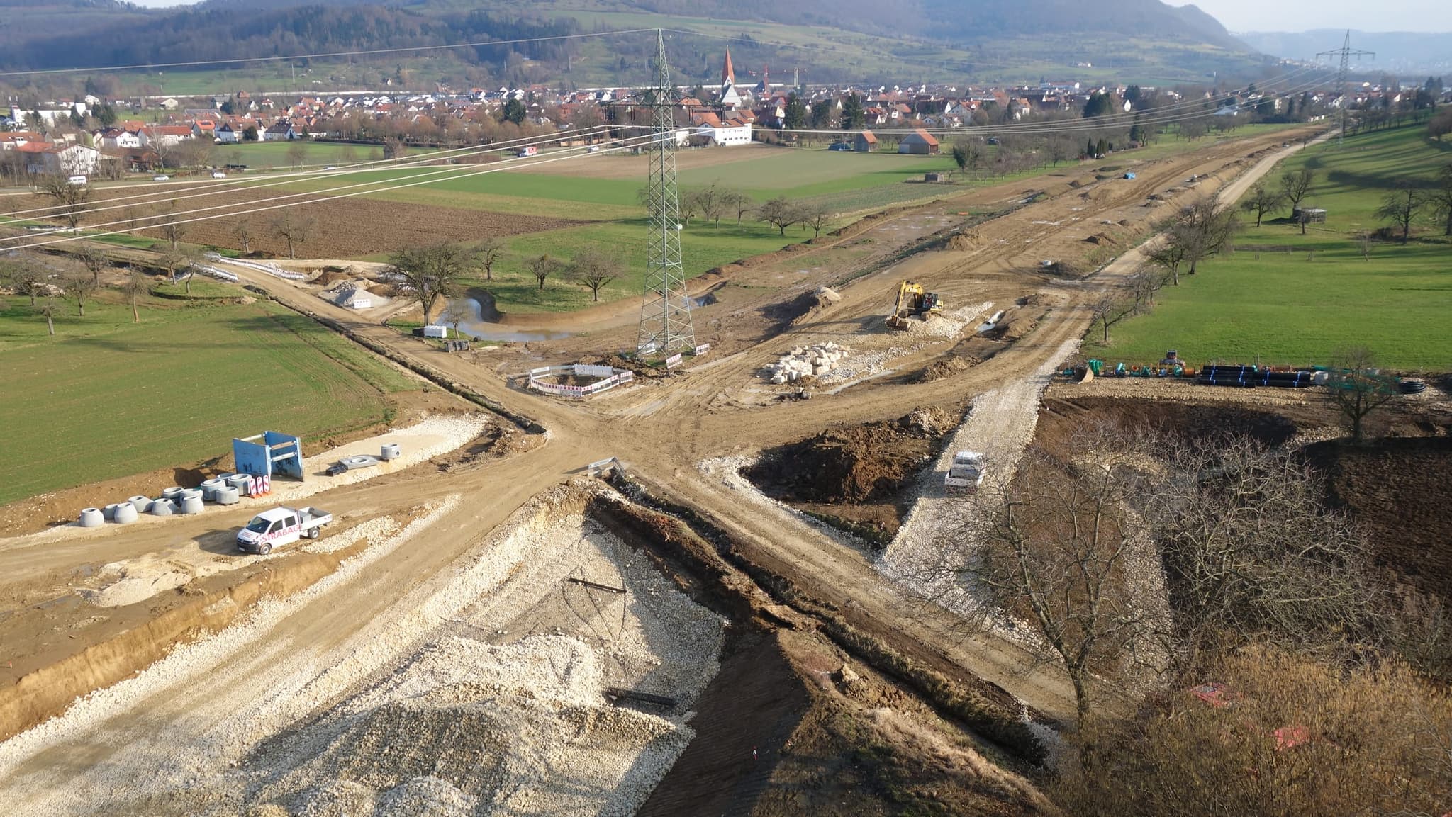 Erdbau im Februar: die Trasse als Rohplanum, im Hintergrund der Ort mit Kirchturm